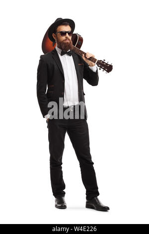 In voller Länge Porträt einer männlichen Musiker mit einer akustischen Gitarre auf seiner Schulter auf weißem Hintergrund posiert Stockfoto