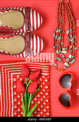 Red feminine Accessoires Reisen shopping Vorbereitung Konzept mit Schuhe, Tasche, Schal und Lippenstift. Stockfoto