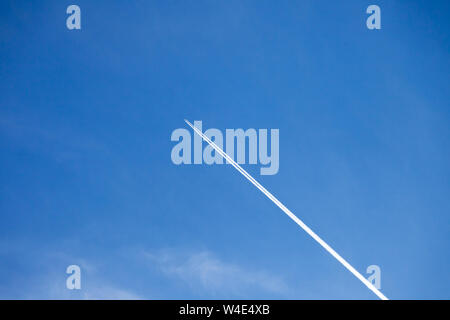 Über Blick in den wunderschönen blauen Himmel, mit einem Flugzeug fliegen hoch verlassen Kondensstreifen hinter in den Weg Stockfoto