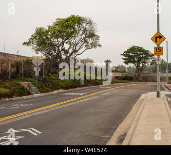 Stadt Straße mit hart rechts abbiegen, doppelten gelben Linien und Bürgersteig. Stockfoto