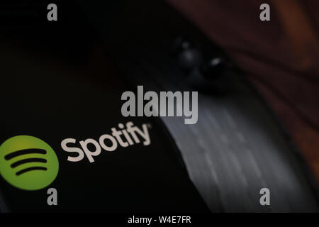 Nizhyn, Ukraine/Juli -16-2019/Smartphone und Kopfhörer auf der Vinyl Platte Spotify Anwendung ausgeführt wird. Medien und app-Konzept Stockfoto