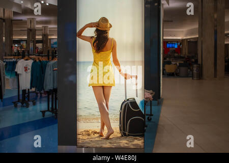 Tampa Bay, Florida. Juli 12, 2019 Gigantography der Frau am Strand mit Gepäck am Internationalen Flughafen Tampa. Stockfoto