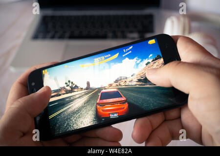 Nizhyn, Ukraine/Juli -16-2019: Hände halten Smartphone und spielen Asphalt 8. Android Spielkonzept. Stockfoto