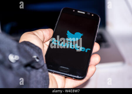 Nizhyn, Ukraine/Juli -16-2019: junge Vertreter der Mann in Schwarz suite halten Sie das Smartphone und nutzen Twitter App. Social Media und körperschaftlichen Konzept. Stockfoto