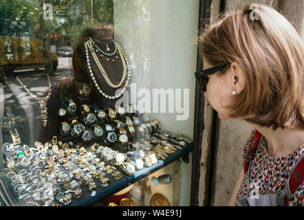 Barcelona, Spanien - Jun 1, 2018: Elegante Frau vor Showcase Fenster auf zentrale juweliergeschäft in der spanischen Stadt Auswahl Ringe, Ohrringe, broches, Perlen und Diamanten Stockfoto