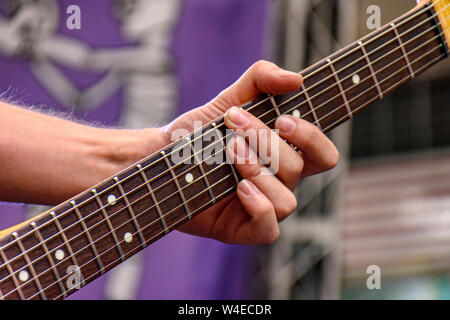 Hände und Finger spielen elektrischen Gitarre während der Leistung einer Band mit einem Rock Konzert Stockfoto