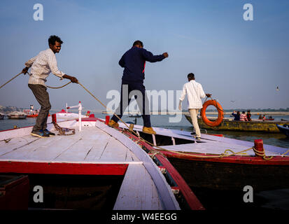 Varanasi, Indien - ca. November 2018: Schiffer von Varanasi mit ihren Booten am Ganges. Varanasi ist die geistige Hauptstadt von Indien, dem heiligsten Stockfoto