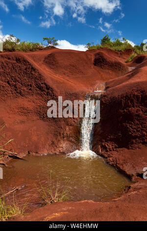Wasserfall und Pool aus einem kleinen Dampffluss über robuste Red Rock Gelände in der Nähe von Waimea Canyon auf Kauai, Hawaii. Stockfoto