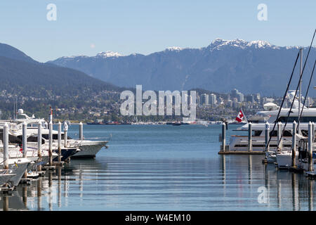 North Vancouver und schneebedeckte Berge vom Coal Harbor aus gesehen ein großer Boot/Jachthafen in der Nähe der Innenstadt von Vancouver, BC. Stockfoto