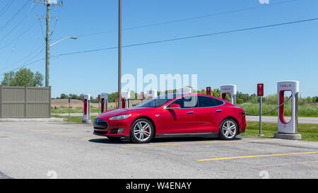 Red Tesla Model S Plug-in laden bei Tesla Kompressor Station und in Port Hope, Ontario. Stockfoto