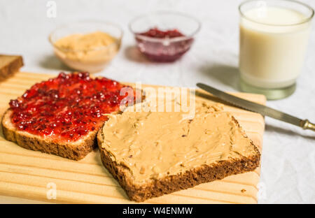 Sandwich mit Erdnussbutter und Marmelade auf einem Holzbrett vor weißem Hintergrund Stockfoto