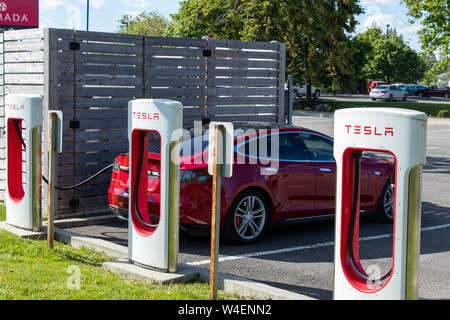 Red Tesla Model S geparkt, Aufladung bei Tesla von Cornwall, Ontario entfernt. Stockfoto