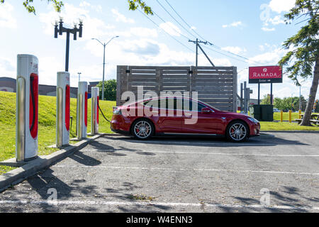 Red Tesla Model S geparkt, das Aufladen bei Tesla Kompressor in Cornwall, Ontario. Stockfoto