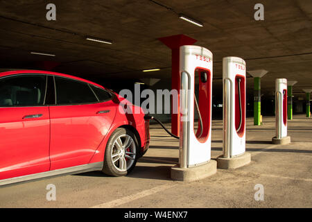 Red Tesla Model S Plug-in in Montreal Tesla Kompressor Lage am Place Vertu Einkaufszentrum während einer hellen Sonnenuntergang. Stockfoto