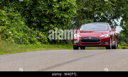 Red Tesla Model S gesehen Fahren auf einer Straße. Stockfoto