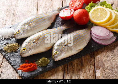 Gesunde Rohstoffe Sarpa salpa mit frischem Gemüse und Gewürze close-up auf einer Schiefertafel Board auf dem Tisch. Horizontale Stockfoto