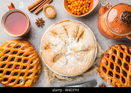 Verschiedene hausgemachte Kuchen mit Zutaten. Crostata - offene Berry pie und Apfelkuchen auf eine Tabelle, Ansicht von oben, von oben Stockfoto