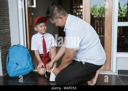 Asiatische elementary Student bereit für die Schule mit Vater Stockfoto