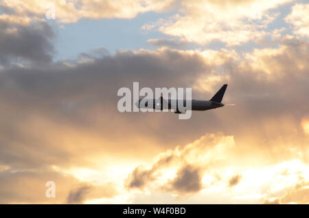 FLUG 419: Kommerzielle Flugzeuge fliegen vom Flughafen Newark in den Abendhimmel. Stockfoto