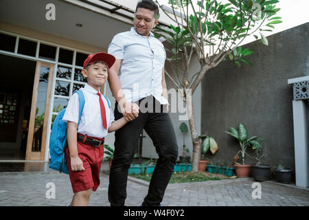 Asiatische elementary Student bereit für die Schule mit Vater Stockfoto