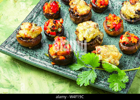 Vegetarisch gefüllte Champignons auf Platte. Italienisches Essen. gebackene Pilze Kappen Stockfoto