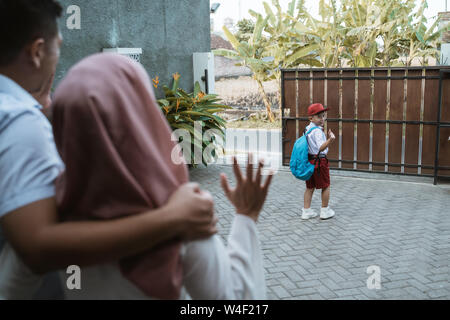 Kid Waving Goodbye zu übergeordneten vor der Schule Stockfoto