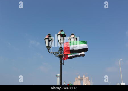 UAE nationale Flagge auf Straßenlaternen in Abu Dhabi Stockfoto