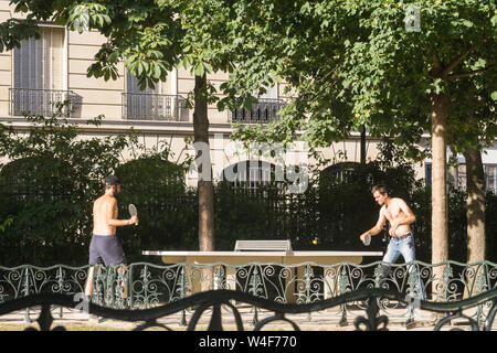 Paris Tischtennis im Park - Zwei junge Männer spielen Tischtennis in einem öffentlichen Park in Paris, Frankreich, Europa. Stockfoto