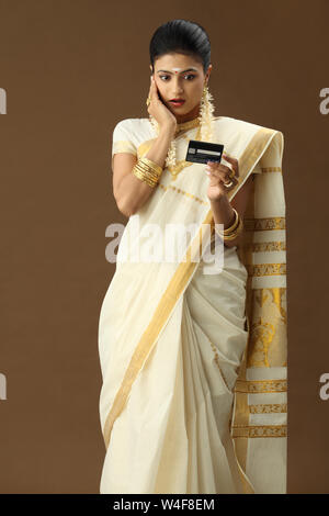 South Indian woman holding eine Kreditkarte und schockiert Stockfoto