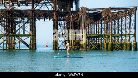 Brighton UK 23. Juli 2019 - Paddel Boarder genießen Sie die warme Sonne am frühen Morgen von der West Pier in Brighton. Hitzewelle Bedingungen sind für den Südosten von Großbritannien mit Temperaturen erwartet, die Mitte der 30er Jahre heute zu erreichen und in den nächsten Tagen erwartet. Foto: Simon Dack/Alamy leben Nachrichten Stockfoto