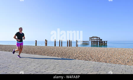 Brighton UK 23. Juli 2019 - ein Läufer genießt die warme Sonne am frühen Morgen von der West Pier in Brighton. Hitzewelle Bedingungen sind für den Südosten von Großbritannien mit Temperaturen erwartet, die Mitte der 30er Jahre heute zu erreichen und in den nächsten Tagen erwartet. Foto: Simon Dack/Alamy leben Nachrichten Stockfoto