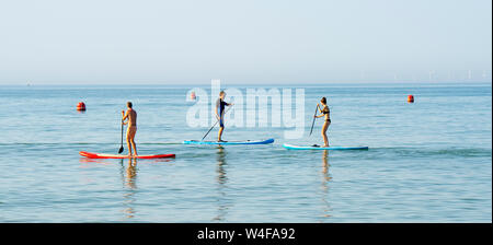 Brighton UK 23. Juli 2019 - Paddel Boarder genießen Sie die warme Sonne am frühen Morgen von der West Pier in Brighton. Hitzewelle Bedingungen sind für den Südosten von Großbritannien mit Temperaturen erwartet, die Mitte der 30er Jahre heute zu erreichen und in den nächsten Tagen erwartet. Foto: Simon Dack/Alamy leben Nachrichten Stockfoto