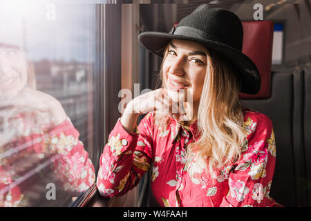 Foto der schönen Mädchen allein im Zug sitzen und schauen aus dem Fenster fröhlich Stockfoto