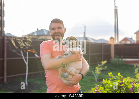 Menschen, Haustiere und Hunde Konzept - junge Mann umarmen funny Jack Russell Terrier im Freien Stockfoto