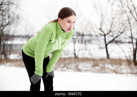 Portrait von erschöpft Frau die Pause beim Joggen auf verschneiten Wintertag Stockfoto