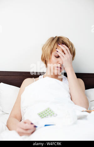 Kranke Frau die Messung der Körpertemperatur im Bett. Stockfoto