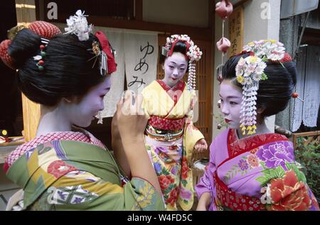 Japan, Honshu, Kyoto, Gion District, drei Mädchen gekleidet als Geisha Kimono tragen, Aufnehmen von Fotos Stockfoto