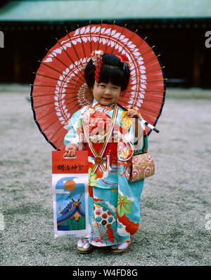 Japan, Honshu, Tokio, junges Mädchen gekleidet in traditionellen Kimono Holding Papier Sonnenschirme für den jährlichen 7-5-3 (Shichi-go-san) auf November 15. Stockfoto