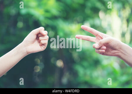 Paar spielen Rock Paper Scissors hand Spiel der Natur grüner Hintergrund Stockfoto