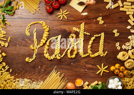 Essen-Schriftzug. Konzept. Verschiedene Pasta auf hölzernen Tisch. Kochen Konzept. Ansicht von oben. Stockfoto