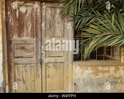 Alte verlassene Steingebäude mit Bars auf das Fenster und Türen aus Holz. Stockfoto