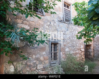 Alten, verlassenen Stein zweigeschossigen Herrenhaus mit Bars an den Fenstern. Stockfoto
