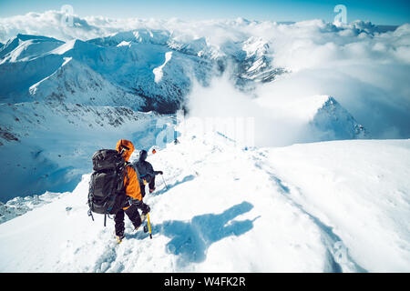 Eine Gruppe von Bergsteigern aufsteigend ein Berg im Winter Stockfoto