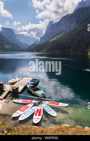 GOSAU, Österreich - 4. JULI 2019: Paddle Surf liegen auf der Oberfläche der vorderen Gosausee in der Nähe der Bank am 4. Juli 2019 in Gosau, Österreich. Stockfoto