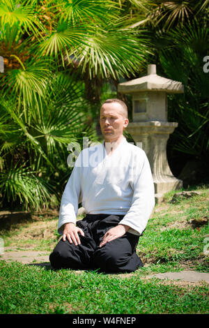 Junge ernster Mann aikido Master in traditioneller Tracht Stockfoto