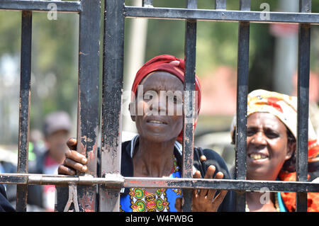 Nakuru, Rift Valley Kenia. 22. Juli, 2019. Frauen, die durch die Post poll Gewalt Blick auf durch eine eiserne Pforte nach Anhörung der wichtigsten Fall Schadenersatzforderungen ausstehende Bestätigung des Status des Verwaltungsrats der IDP ausgesetzt war betroffen. Die Regierung die Schuld für die unregelmäßig Entschädigung fake IDP's und Unschuldige mit nichts wurde. Die über 100 000 Menschen, die von Kenias post betroffen - Wahl Gewalt haben Geschmachtet worden in Armut für Jahre, wie sie für den Ausgleich von der Regierung warten. Kenia 2007-2008 Post poll Gewalt führte zum Tod, Vertreibungen und des Stockfoto