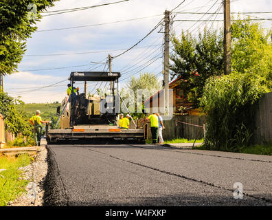 Arbeiter in der Nähe der Asphalt Maschine über den heißen Asphalt mit Schaufeln auf den Straßenbau. Stockfoto