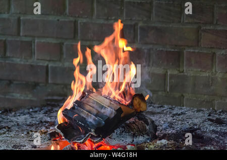 Brennholz Brennholz wird in einer retro geöffnet rustikal gemauerten Kamin verbrannt. Stockfoto