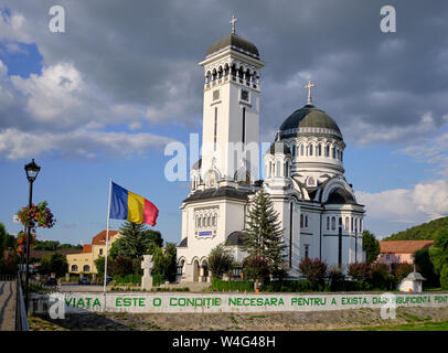 Orthodoxe Kirche der Heiligen Dreifaltigkeit in Sighisoara mit fliegenden rumänische Flagge vor, und die Nachricht auf der Wand in Grün Stockfoto