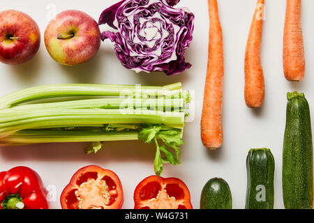 Flach mit frischen Karotten, Lauch, Äpfel, Paprika und Zucchini auf weißem Hintergrund Stockfoto